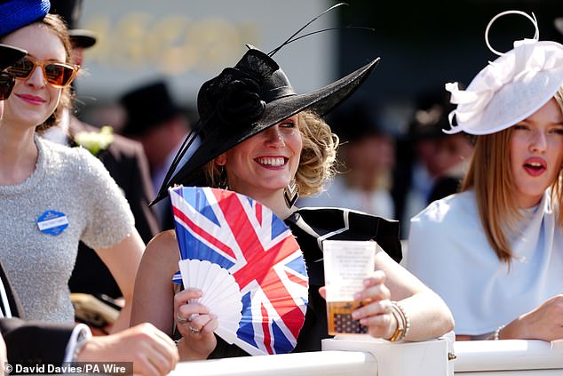 A racegoer cools down with a fan on day three of Royal Ascot