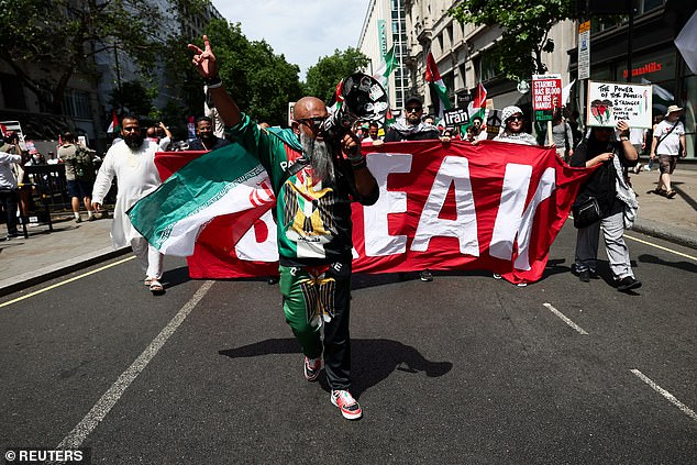 A man uses a megaphone as pro-Palestinian demonstrators march through central London