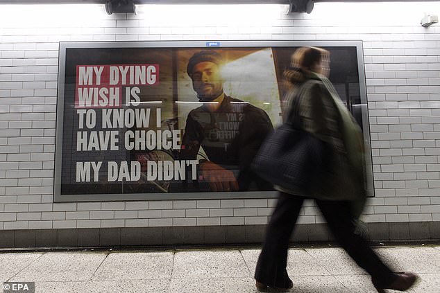 Pictured: Pedestrians walk past the posters promoting the Assisted Dying bill at Westminster Underground station