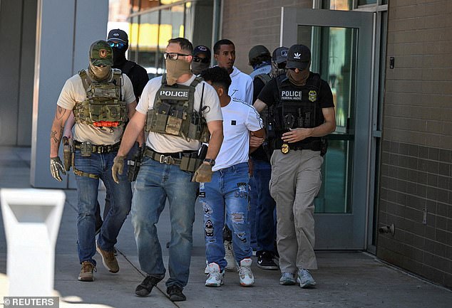 Immigration officers have swooped on amateur football matches in the United States (pictured: ICE agents and law enforcement officers outside an immigration court in Phoenix, Arizona)
