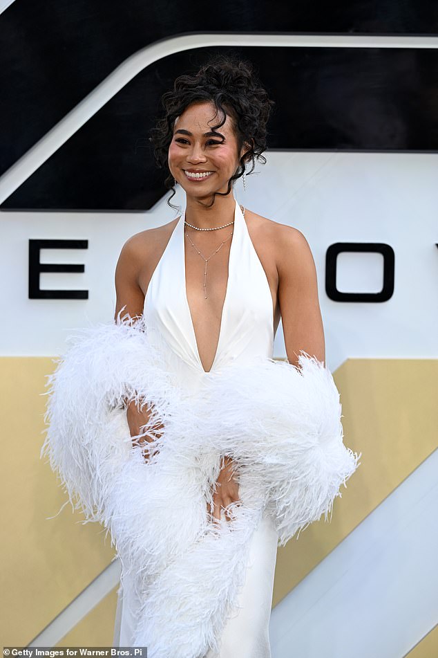 Rosie Dwyer turned heads with an old Hollywood white halter-neck gown that featured a dramatic white feathered stole draped around her arms