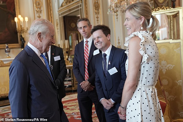 King Charles III speaks with Will Straw and Declan Donnelly (centre) and his wife Alison, during a reception for winners of the King's Trust Awards 2025 at Buckingham Palace