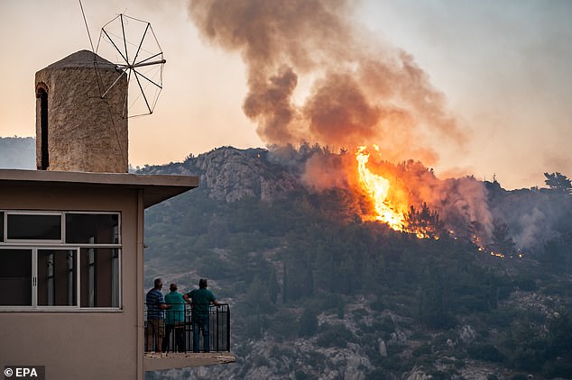 GREECE: People watch as a wildfire burns forest land on Chios Island, Greece, on June 23