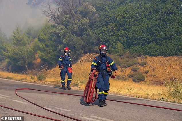 GREECE: Greek authorities have had to issue multiple evacuation orders as wildfires tear across the country. Pictured: A firefighter carries a hose as a wildfire burns on Chios island, June 24
