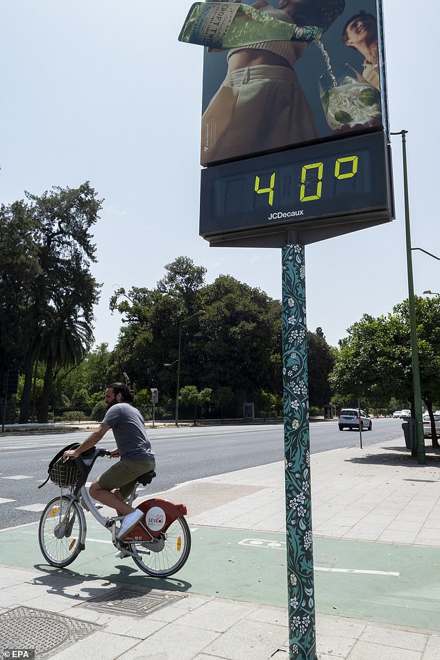 SPAIN: A cyclist rides next to a thermometer showing 40 degrees Celsius in Seville