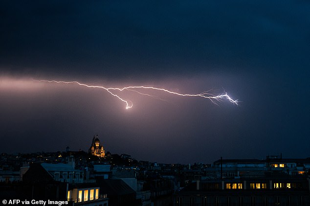 FRANCE: A lighting bolt lights up the sky over Sacre Coeur Basilica in Montmartre during a thunderstorm, northern Paris, on June 25