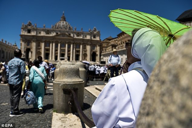 VATICAN CITY -- A woman takes shelter from the sun with an umbrella during a heatwave in Saint Peter's Square