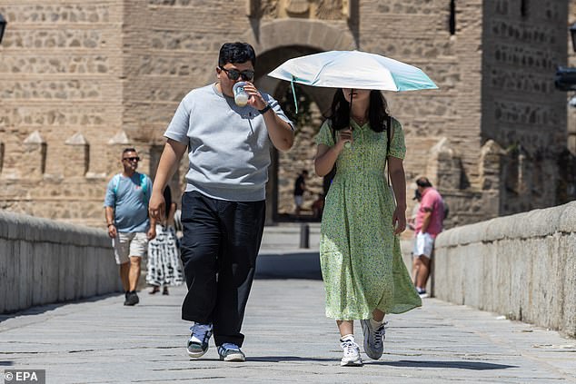 SPAIN -- A tourist uses an umbrella to protect herself from the sun during a heatwave in Valencia