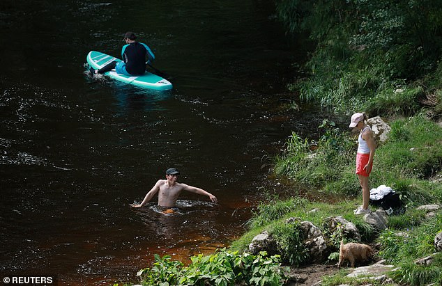 CUMBRIA -- People cool off in the River Lune, in market town Kirkby Lonsdale