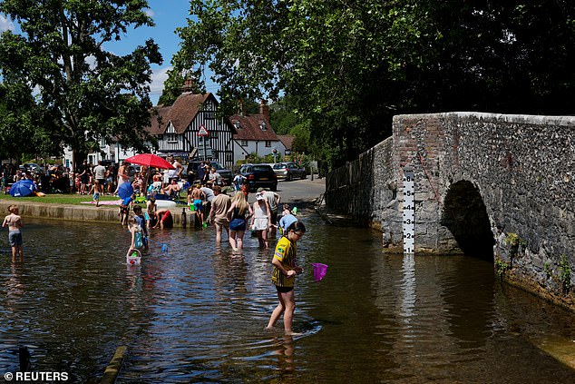 EYENSFORD -- People keep cool in the ford in River Darent, as an amber heat warning was issued