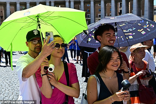 VATICAN CITY -- People shelter under umbrellas in the heat as Pope Leo XIV addresses the crowd from the window of the apostolic palace overlooking St. Peter's Square