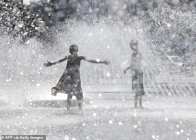 GERMANY -- Children play in a fountain at Munich's Karlsplatz square