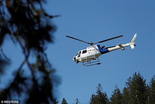 A United States Customs and Border Protection helicopter lifts off from Cherry Hill Park in search of the shooters