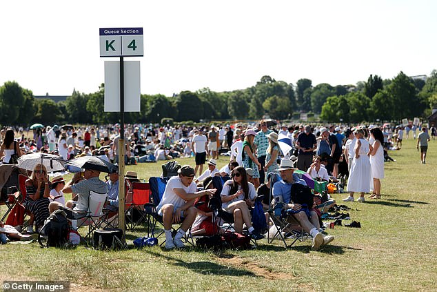 Spectators wait in the baking sun in Wimbledon Park