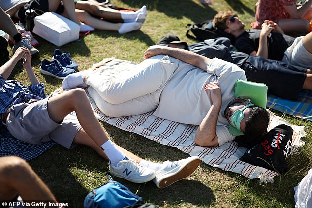 Tennis fans lay down and rest as they queue for tickets on the first day of the 2025 Wimbledon Championships