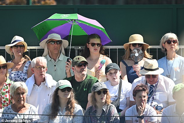 Umbrellas up around the courts of Wimbledon today as temperatures rise into the 30s
