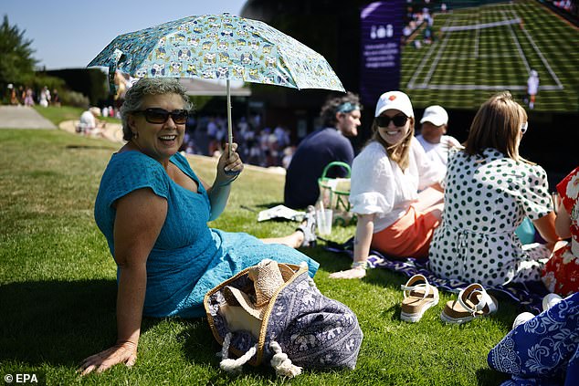Spectators use umbrellas to protect from the sun