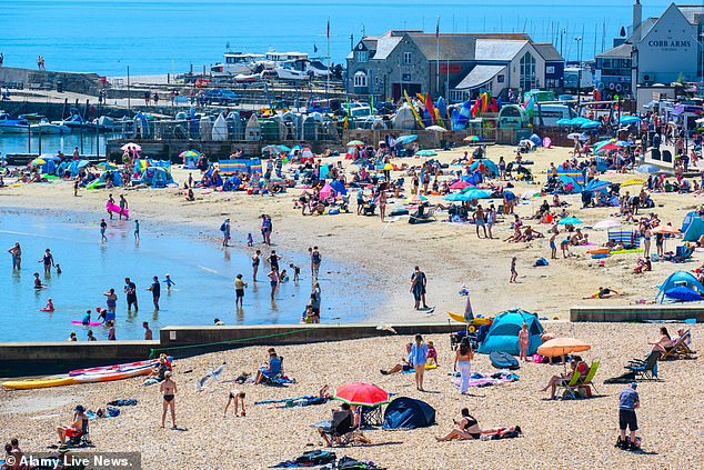 Sunbathers flocked to the packed beach at the seaside resort of Lyme Regis to bask in the scorching hot sunshine