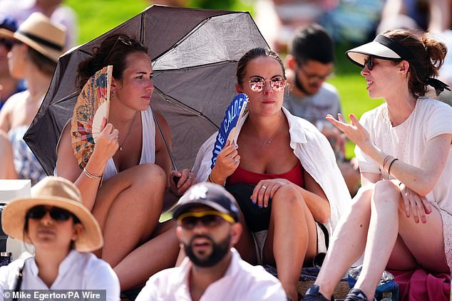 Spectators shelter from the sun on day one