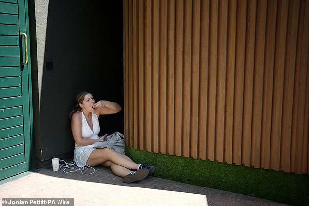A spectator shelters from the heat on day one of the 2025 Wimbledon Championships