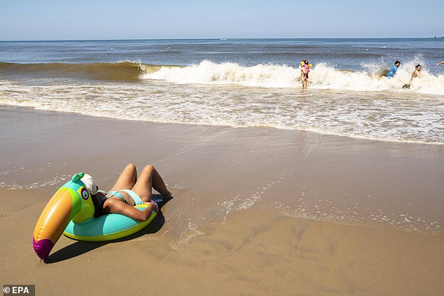 Bathers spend time in the sun on the beach in Scheveningen, The Hague
