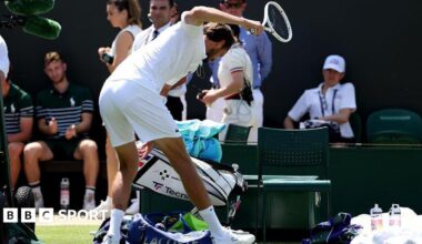 Daniil Medvedev smashes his racquet after losing his first-round match at Wimbledon