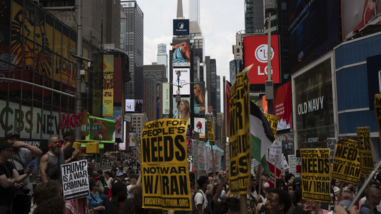 Protesters hold signs during a protest against U.S. strikes on Iran, Sunday, June 22, 2025, in New York. AP/PTI(AP06_23_2025_000007B)(AP)