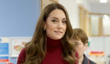 Kate Middleton wears a red polo neck sweater and has long curly brown hair