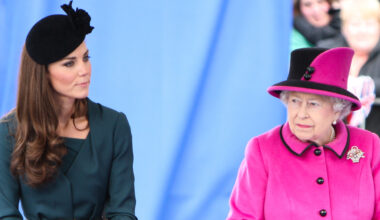 Kate Middleton wears a dark green dress with a black hat and Queen Elizabeth wears a bright pink coat