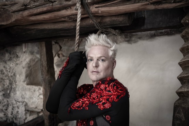 Andy Bell in a promo image for his new album Ten Crowns Andy Bell in a black and red jacket holding onto a rope