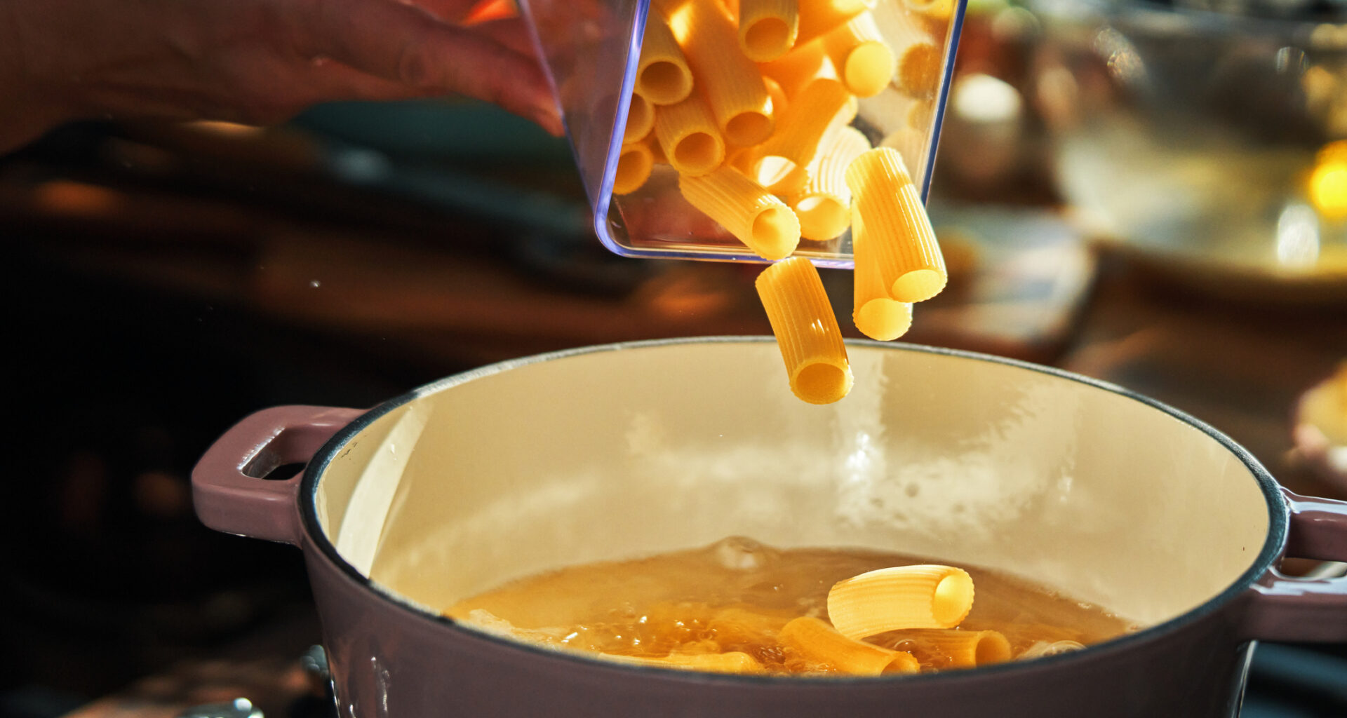 Glass jar of pasta being poured into casserole dish