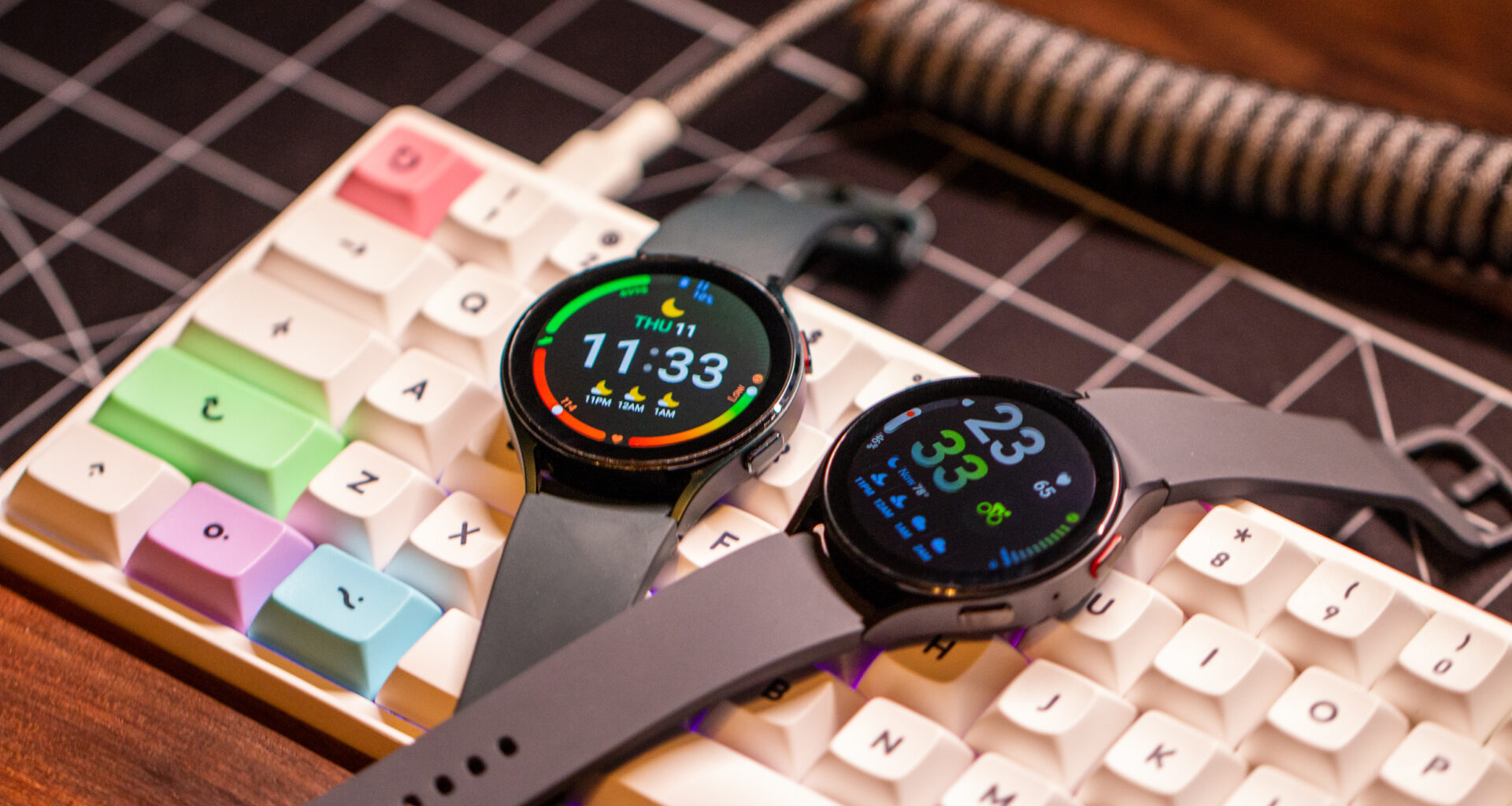 Samsung Galaxy Watch 5 vs Galaxy Watch 4 both screens on sitting atop keyboard