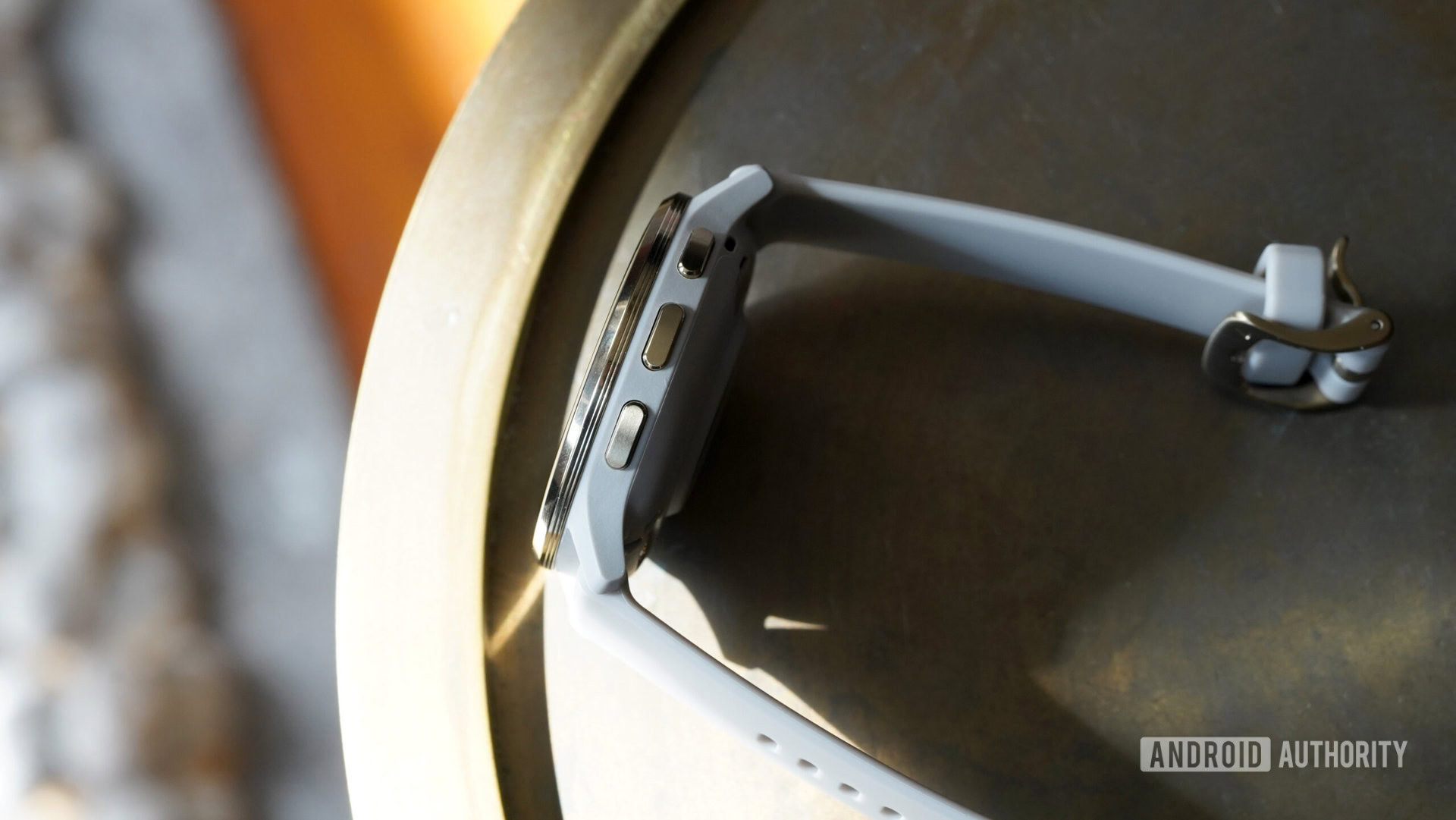 A Garmin Venu 3 rests on its side, revealing the device's three buttons.