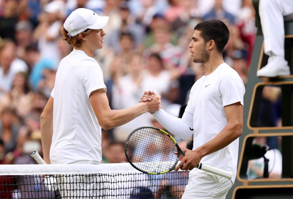 Jannik Sinner and Carlos Alcaraz shake hands at Wimbledon in 2022.