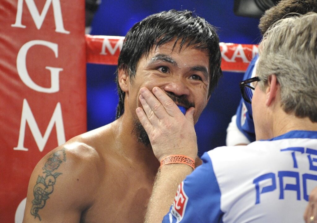 Freddie Roach puts Manny Pacquiao's gumshield in between rounds during the fight with Tim Bradley