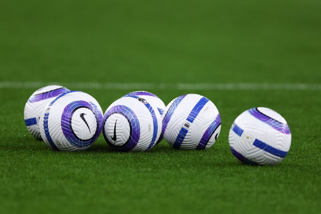 Several Premier League match balls on the turf before a Liverpool match