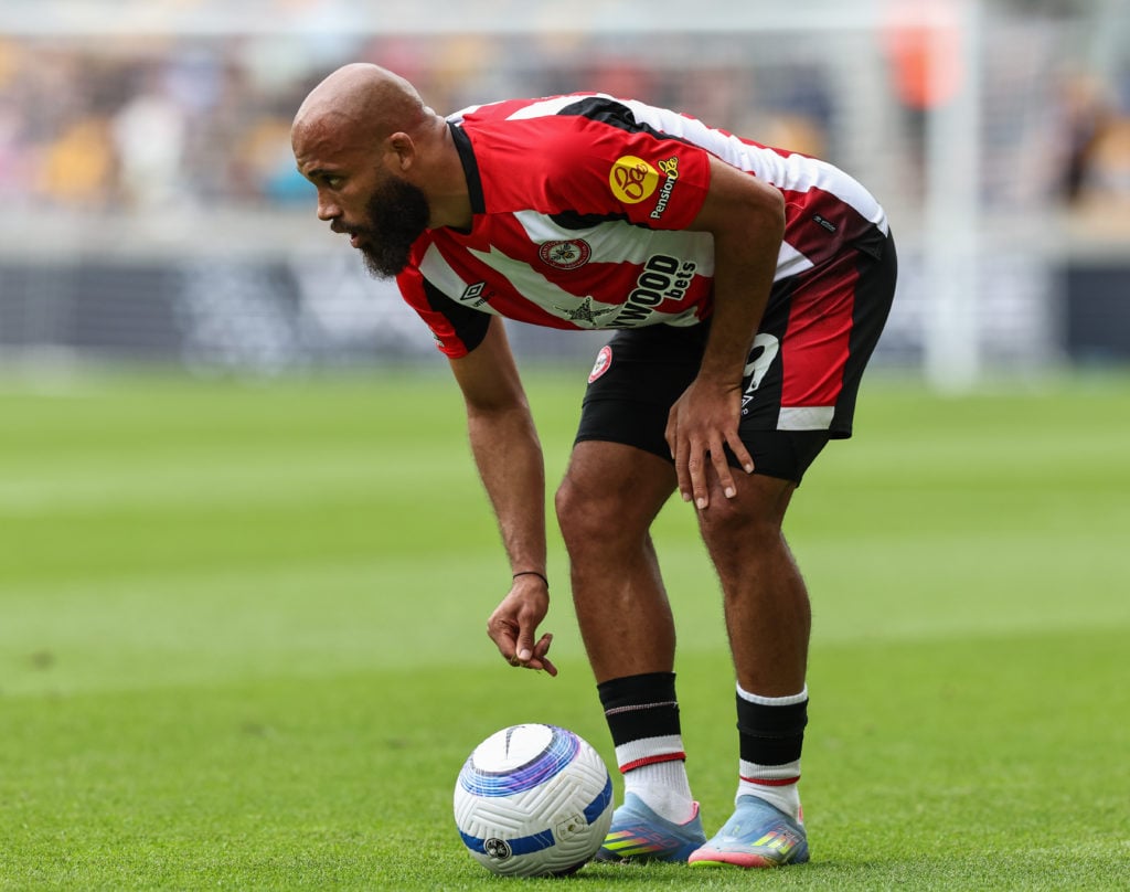 Bryan Mbeumo bent over to place ball for free-kick for Brentford.