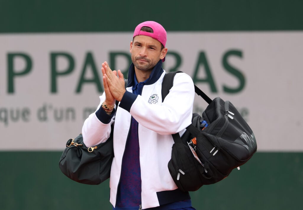 Grigor Dimitrov of Bulgaria applauds spectators after retiring injured from his Men's Singles First Round match against Ethan Quinn of United States during Day Three of the 2025 French Open at Roland Garros.