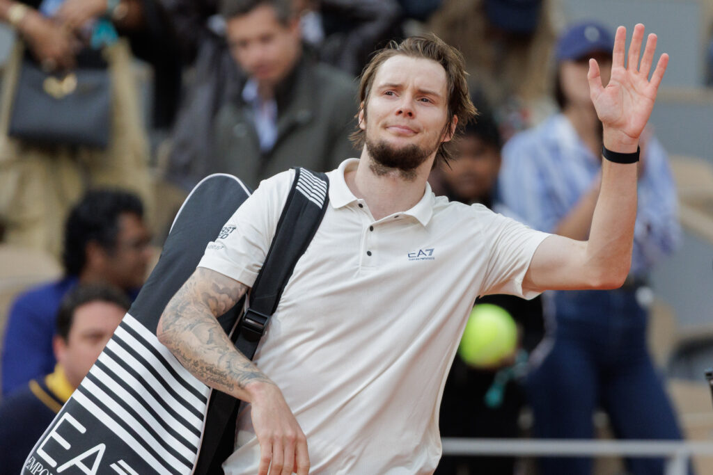 Alexander Bublik waves goodbye to the crowd after losing to Jannik Sinner at the 2025 French Open