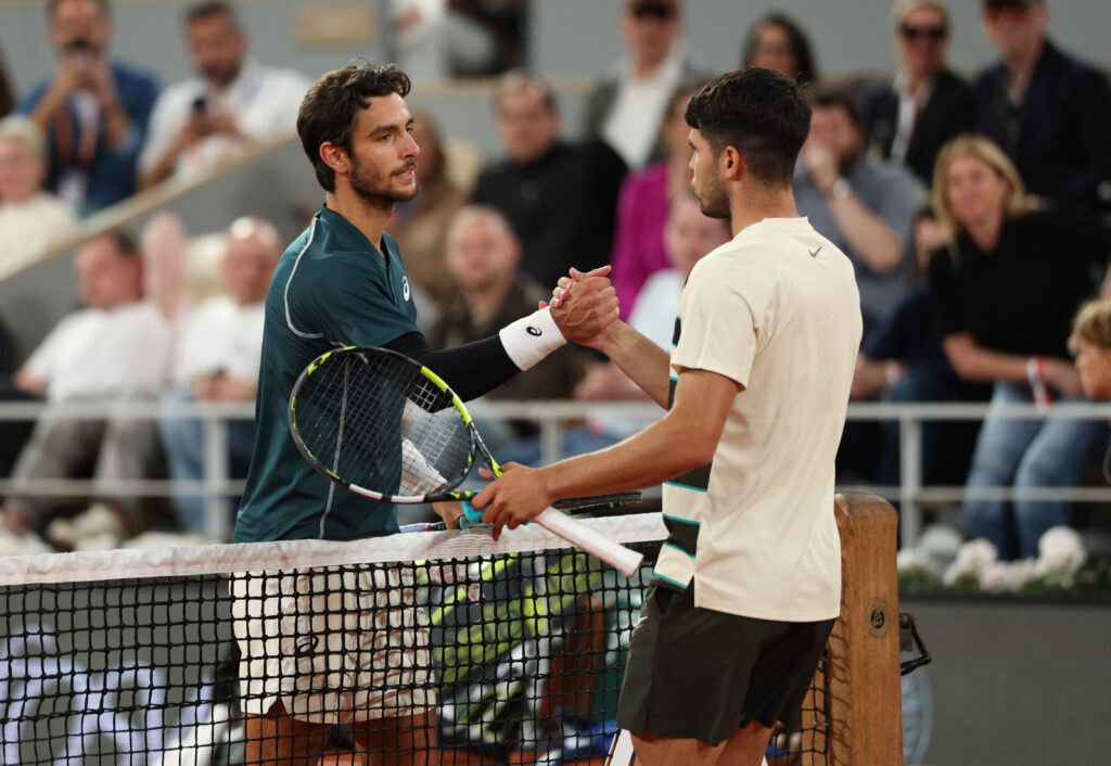 Carlos Alcaraz and Lorenzo Musetti shake hands at the net after their 2025 French Open match