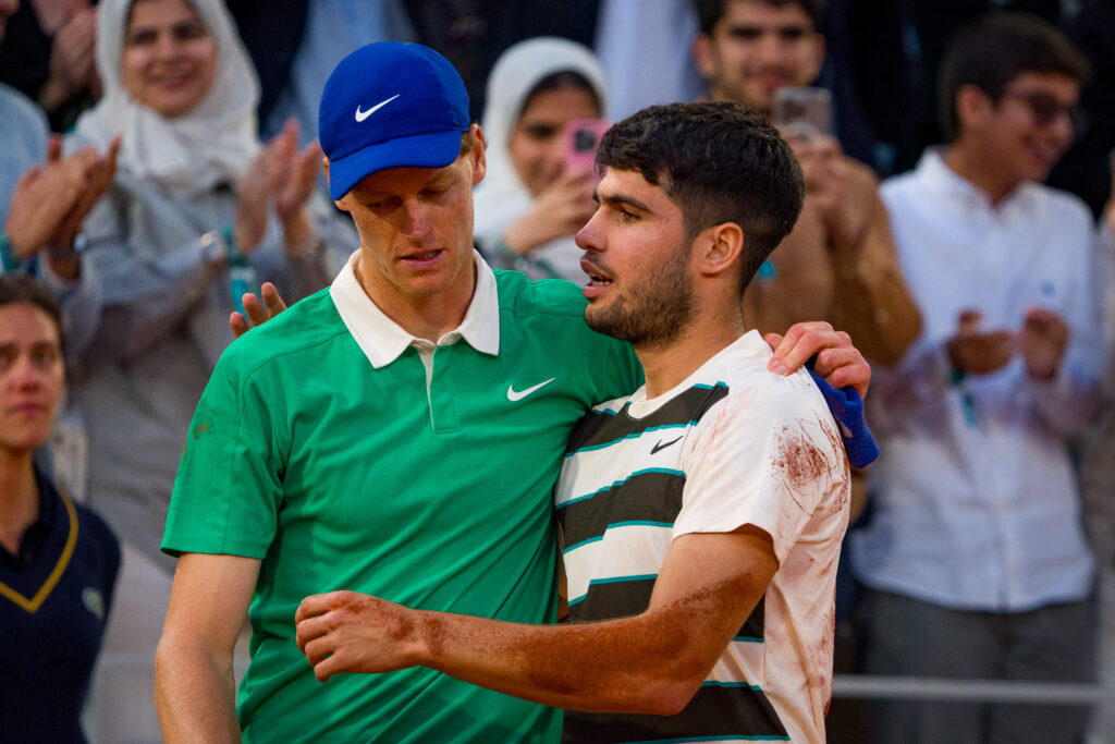 Jannik Sinner and Carlos Alcaraz embrace after the 2025 French Open final