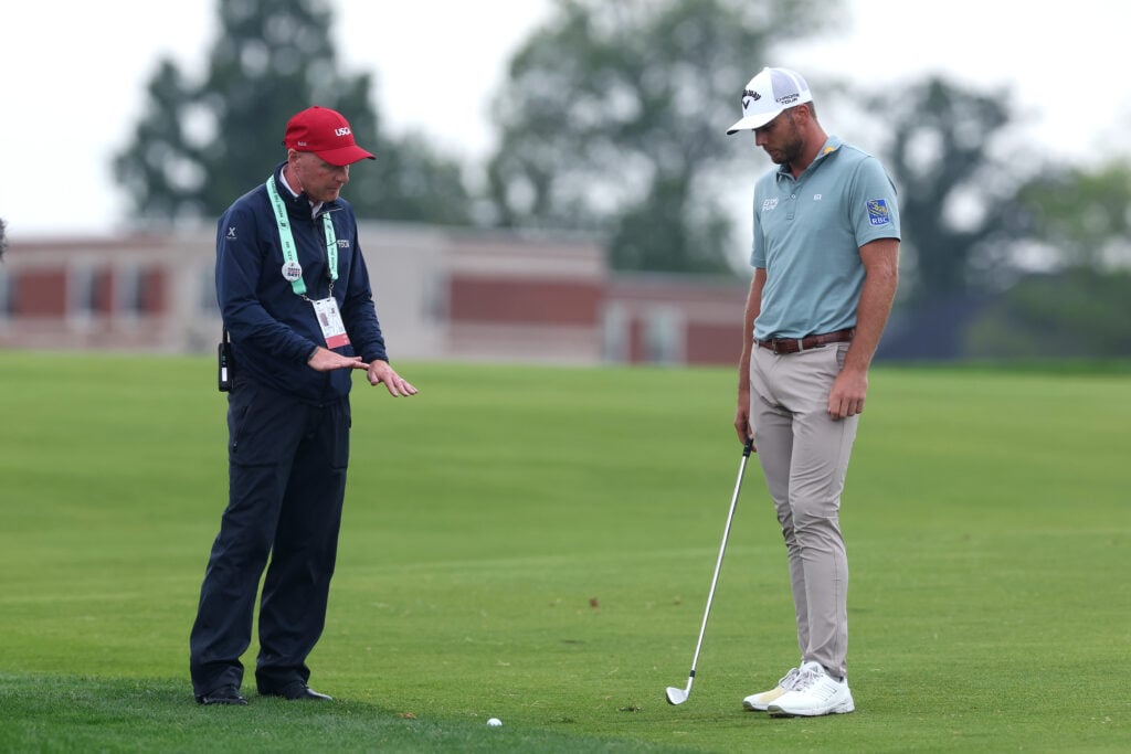 Sam Burns talks to a rules official on the 15th hole at Oakmont during the final round of the US Open