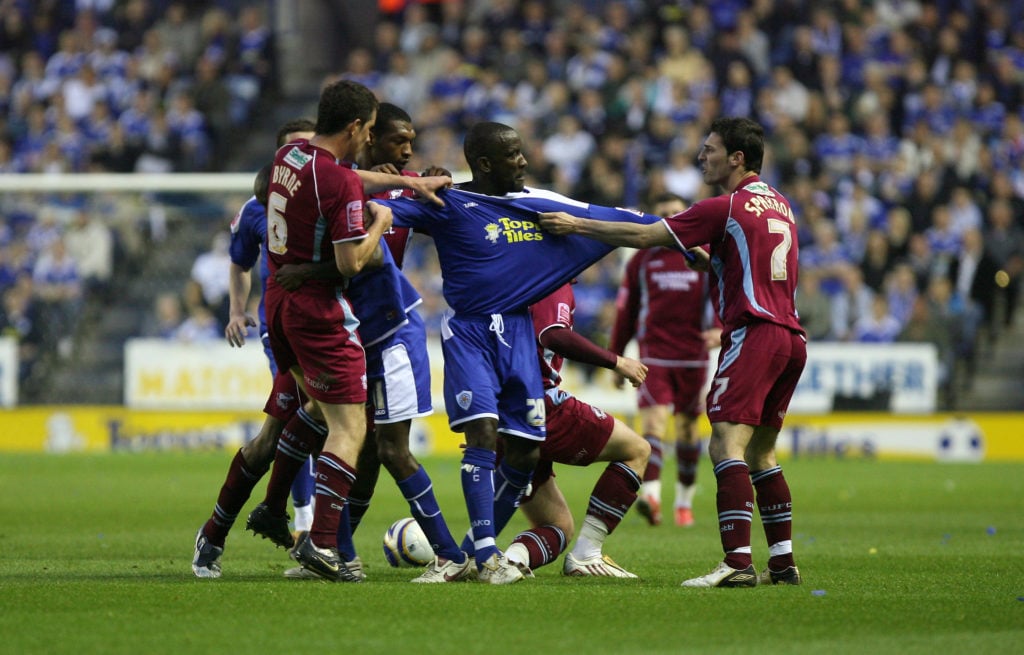 Chis Powell tries to break up a melee between Leicester City and Scunthorpe United players