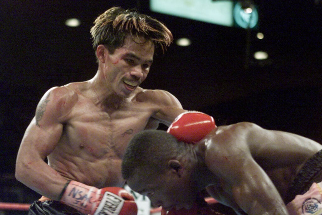 Lehlo Ledwaba ducks under a punch from Manny Pacquiao, whose hand is on the back of his head in their fight