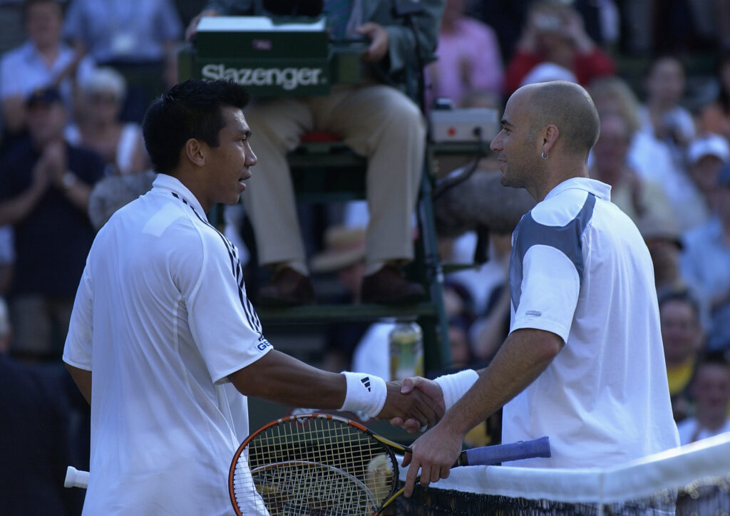 Andre Agassi and Paradorn Srichaphan shake hands at the net at Wimbledon in 2002