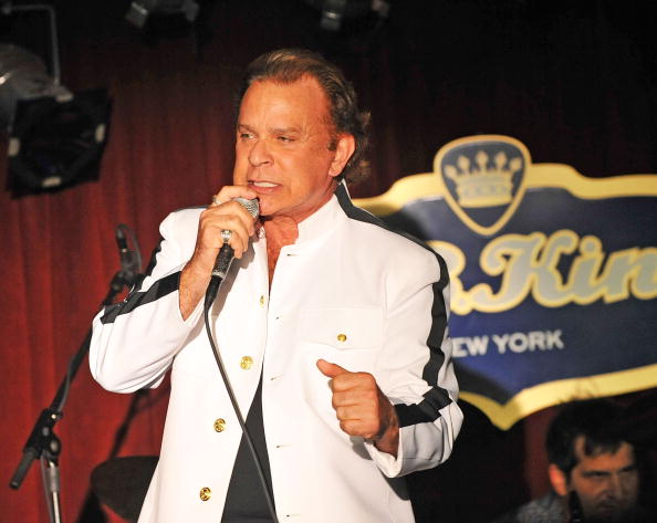 Lou Christie sings onstage in a white jacket for Rockers on Broadway: Celebrating The 60's in 2009