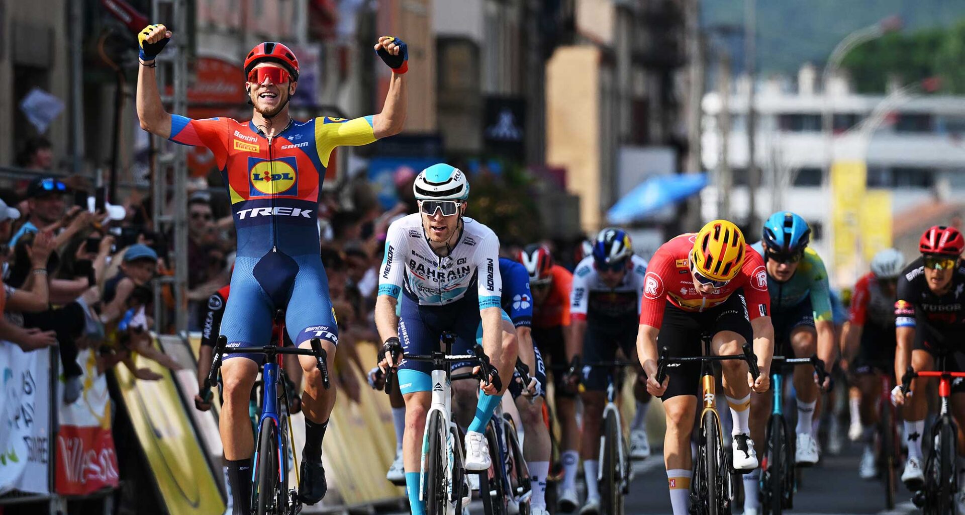 Fred Wright of Bahrain Victorious follows Jonathan Milan of Lidl-Trek across finish line into Issoire
