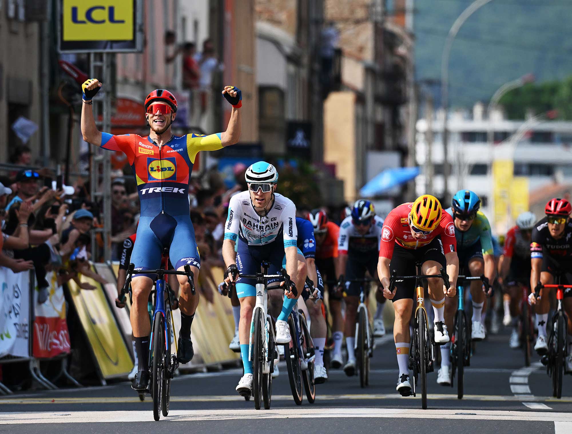 ISSOIRE FRANCE JUNE 09 LR Jonathan Milan of Italy and Team Lidl Trek celebrates at finish line as stage winner ahead of Fred Wright of Great Britain and Team Bahrain Victorious and Stian Fredheim of Norway and Team UnoX Mobility during the 77th Criterium du Dauphine 2025 Stage 2 a 2046km stage from Premilhat to Issoire UCIWT on June 09 2025 in Issoire France Photo by Dario BelingheriGetty Images
