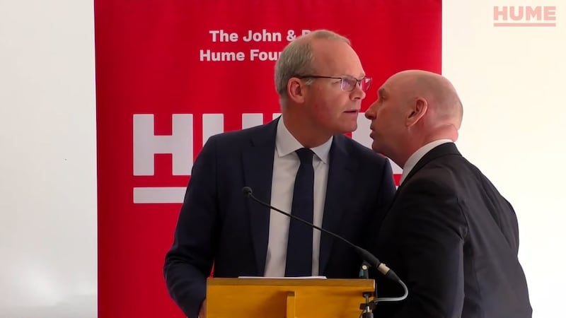Simon Coveney is informed of a security alert while speaking at a peace-building event at The Houben Centre in Belfast