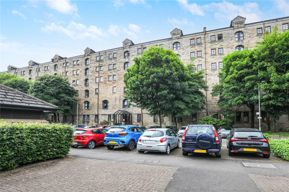Apartment building with cars parked in front.